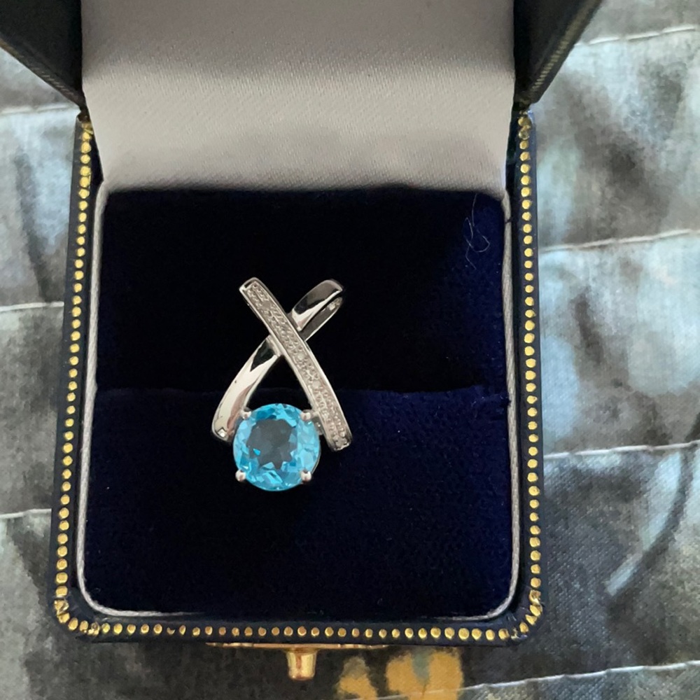 White gold “enhancer”/pendant with blue stone.